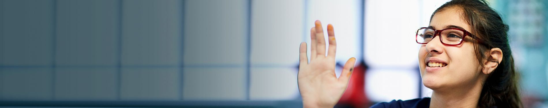 An Insightful Minds student raising a hand in class